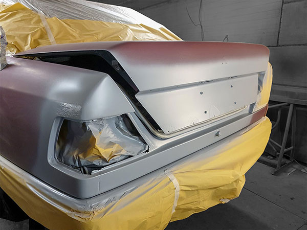 Auton perässä on korjauksen jälkeen paikkamaalattavaa. Muut alueet suojataan maalisumulta.